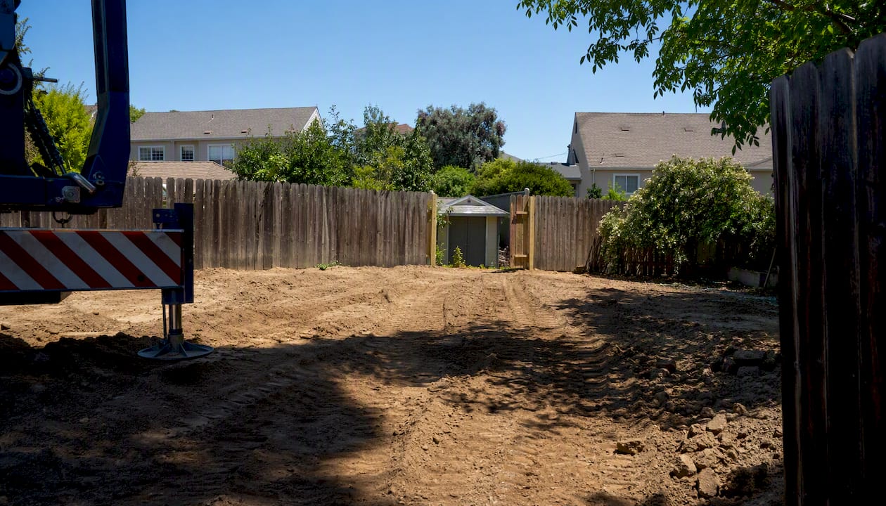 Backyard lot with crane and fence removal for ADU