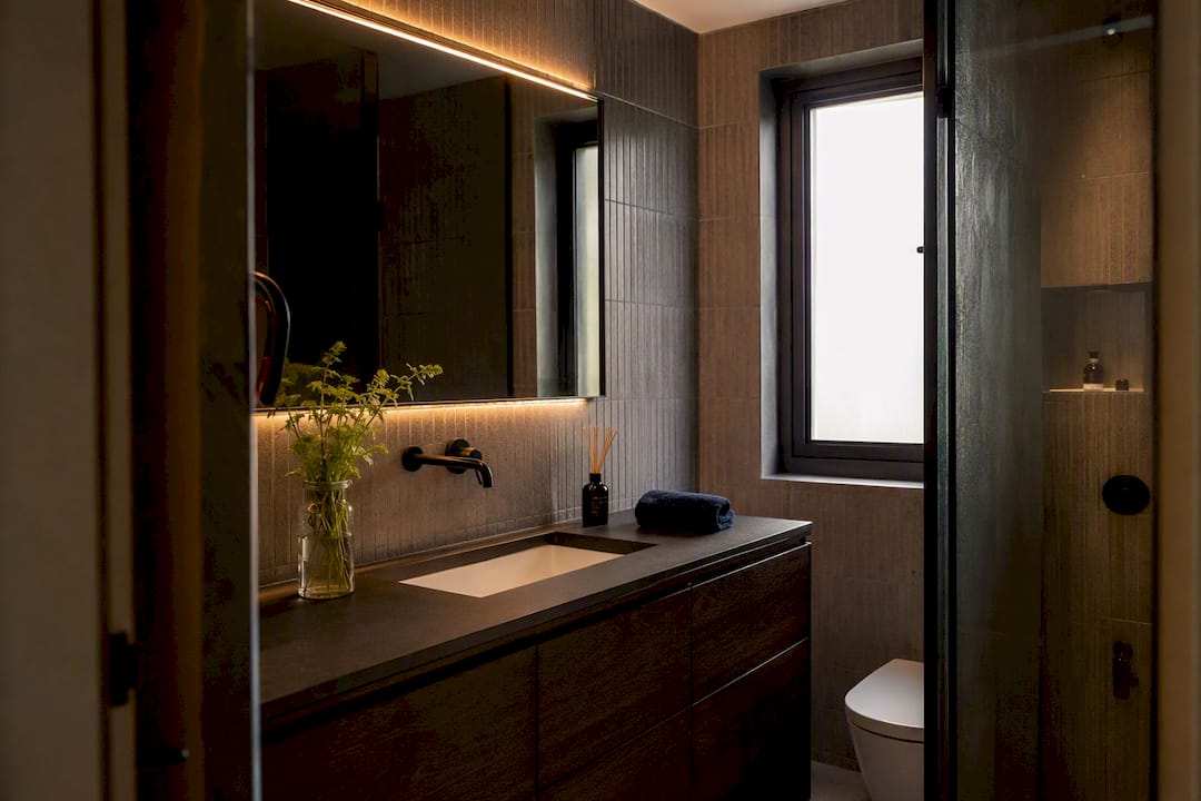 Small bathroom with illuminated mirror and bright lighting